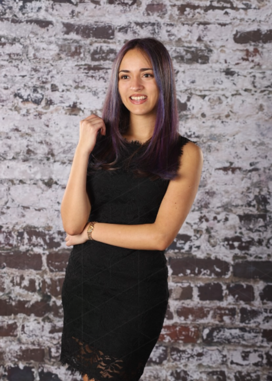 Angelina in formal portrait against a textured brick wall
