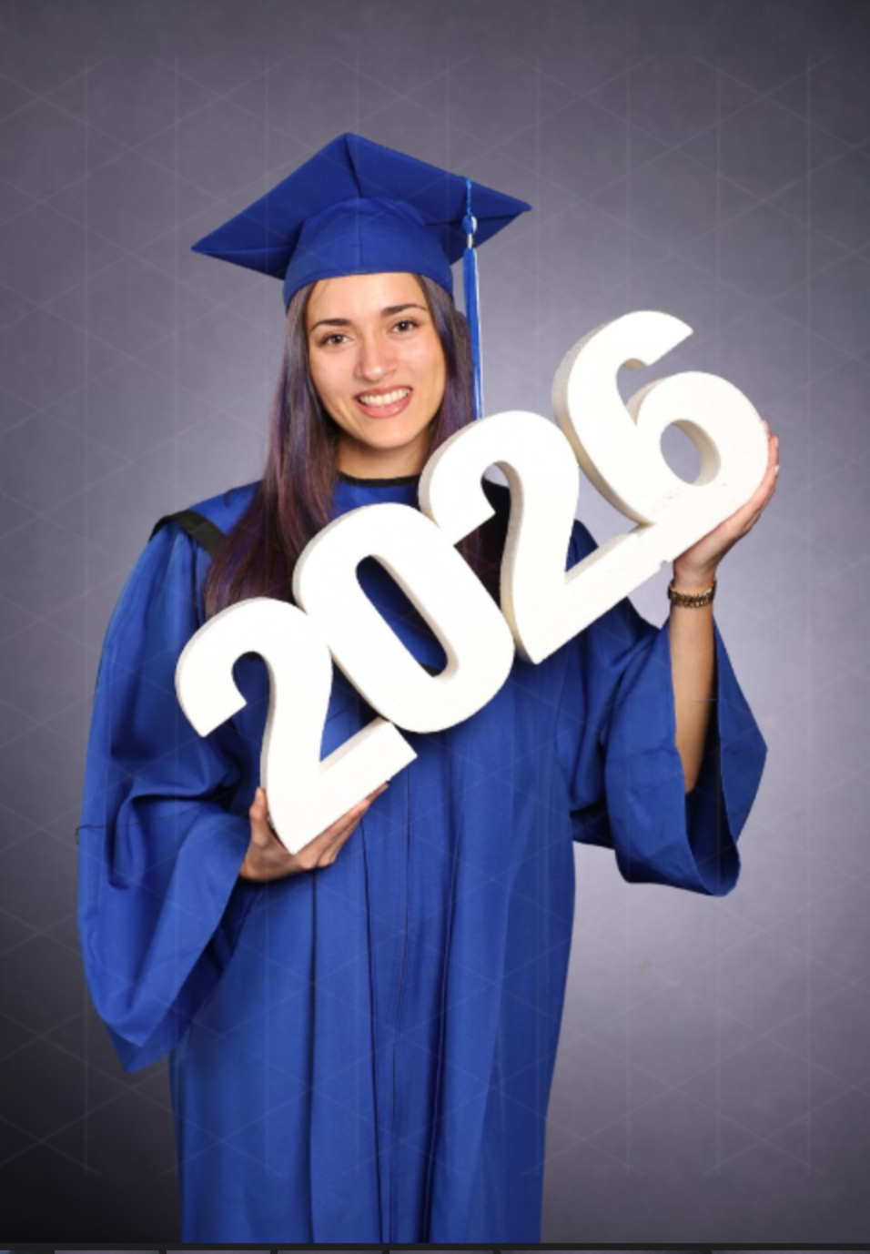 Angelina in cap and gown holding 2026 letters